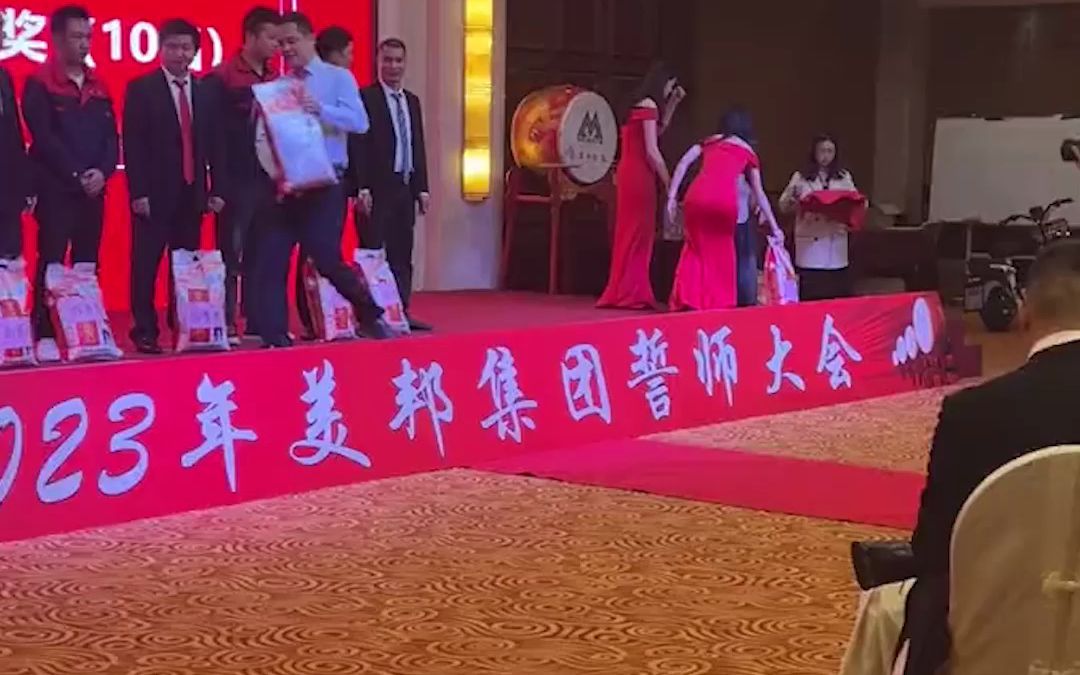 公司颁奖环节送大米 礼仪小姐姐使出洪荒之力 整个过程还不忘微笑
