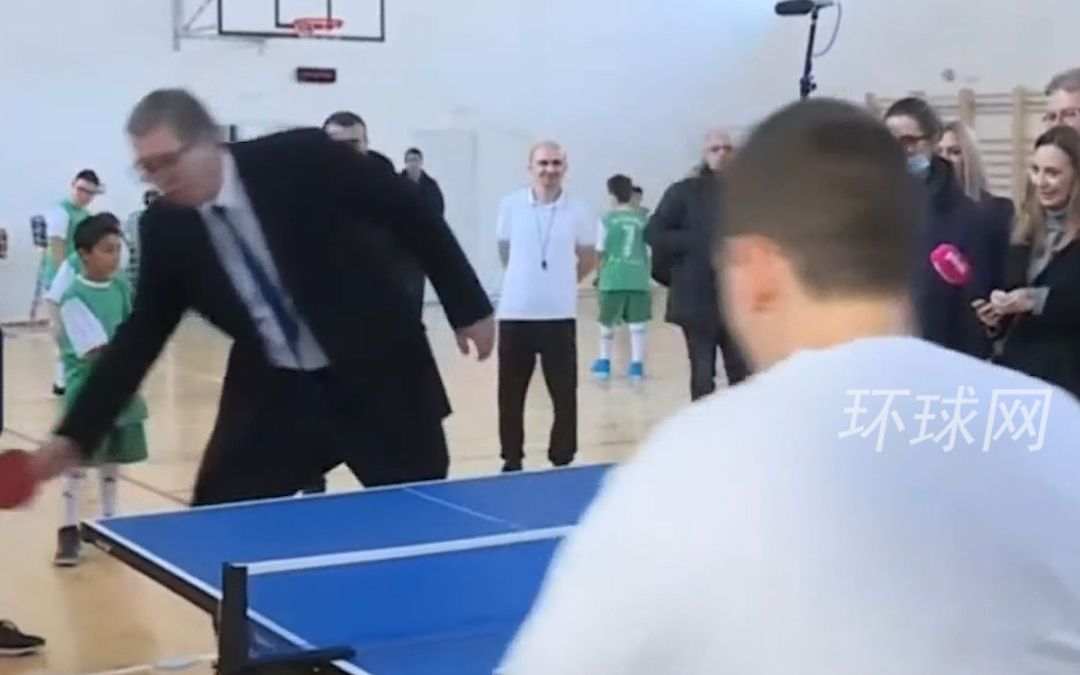 武契奇访问当地一所小学时，与学生一起打乒乓球