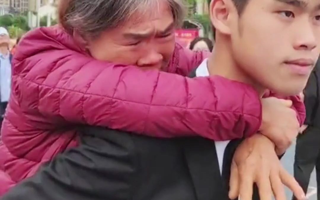 学校成人礼男孩从容背起妈妈 满头白发的妈妈早已哭成泪人