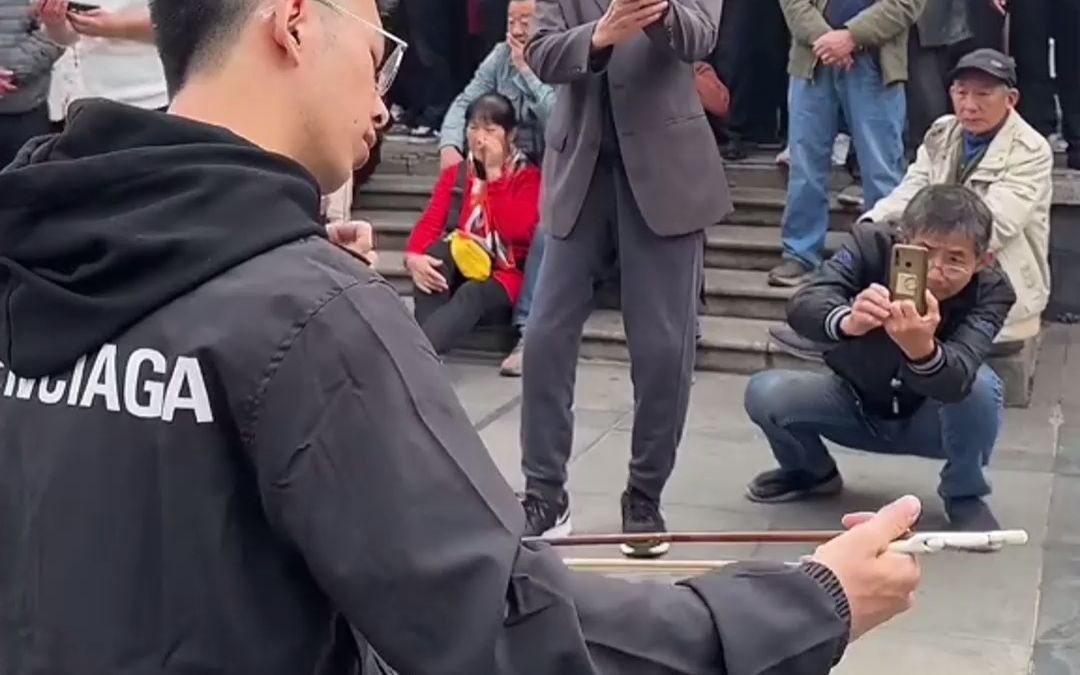 小伙在公园拉二胡，周围坐满大爷大妈围观。网友:越长大越觉得二胡有韵味