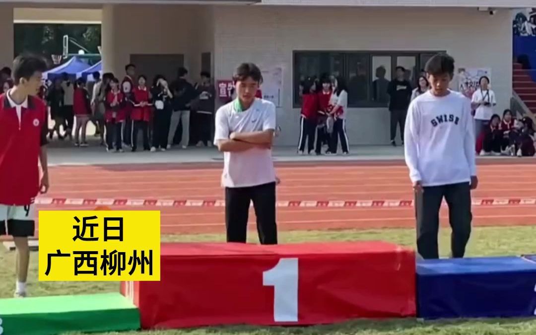 高中运动会现场，男生上台领奖展示二十多块金牌。“基本每个项目都有奖牌”