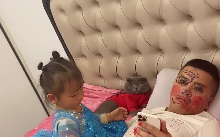 女儿在爸爸身上画画 猫咪在一旁看呆