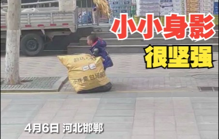 幼童大风中牢牢守住包裹生怕被吹走 小小身影却很坚强
