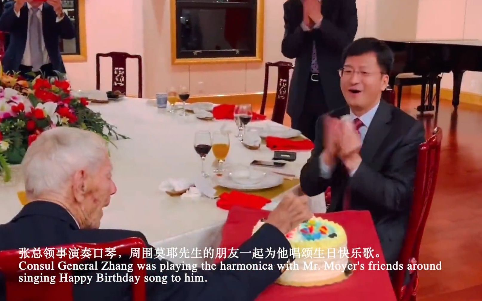 中国驻旧金山总领馆为飞虎队老兵莫耶庆祝102岁生日。众人合唱《生日快乐》歌，总领事张建敏吹口琴伴奏