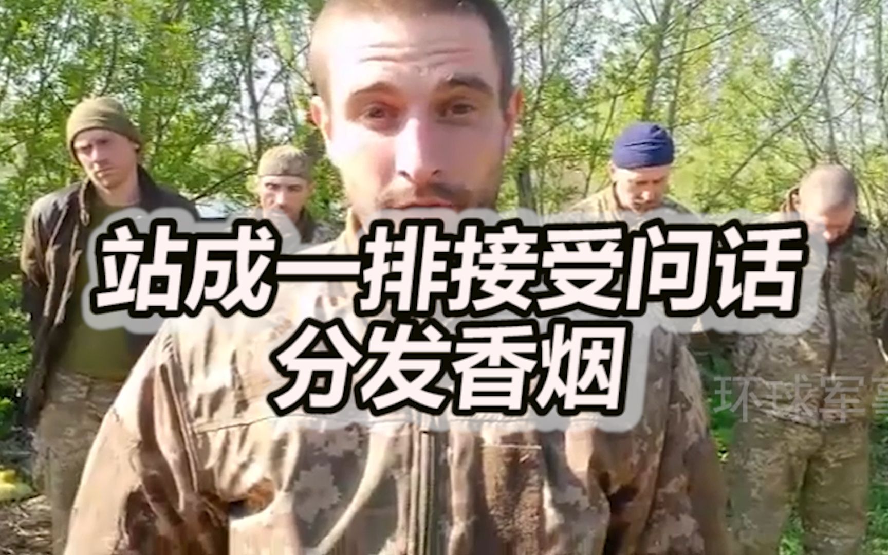 俄军士兵俘虏一整队乌军士兵，站成一排接受问话还给分发香烟
