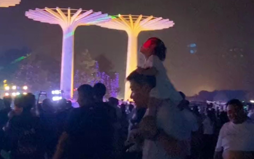 小女孩坐在爸爸肩膀上，随音乐快乐“蹦迪”