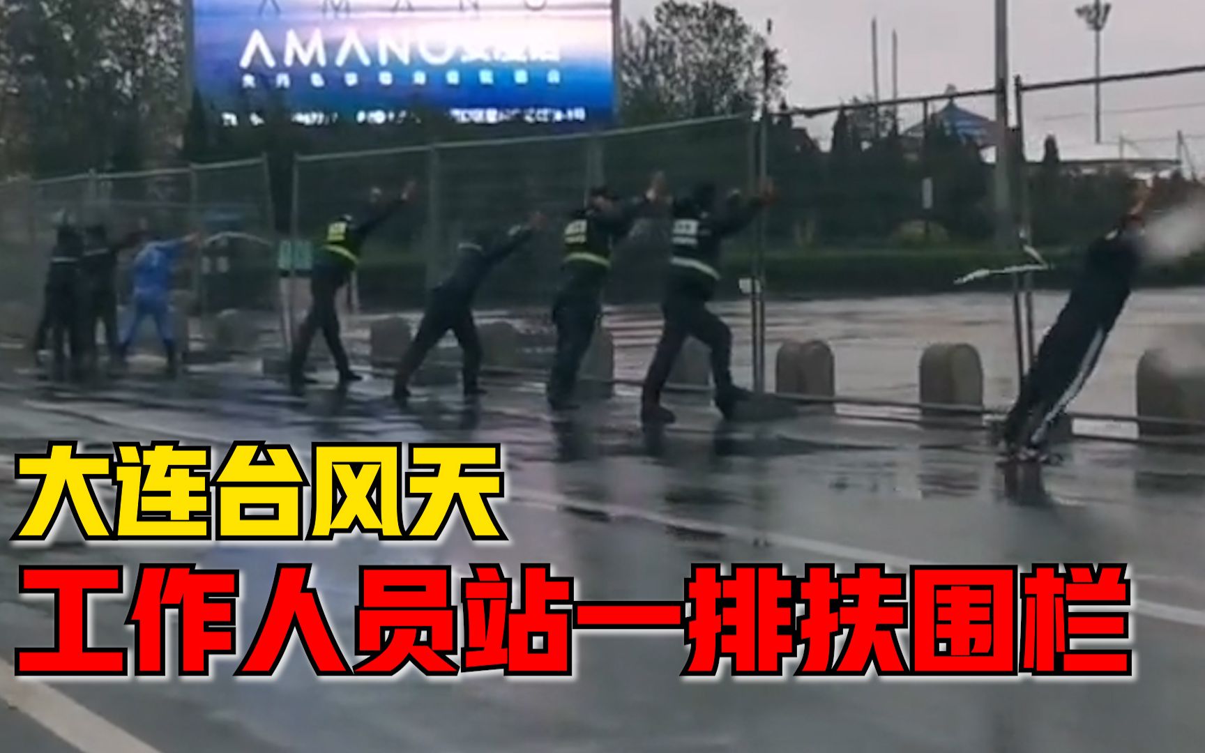 大连台风天工作人员站一排扶围栏，市民：当时风特别大，很感动