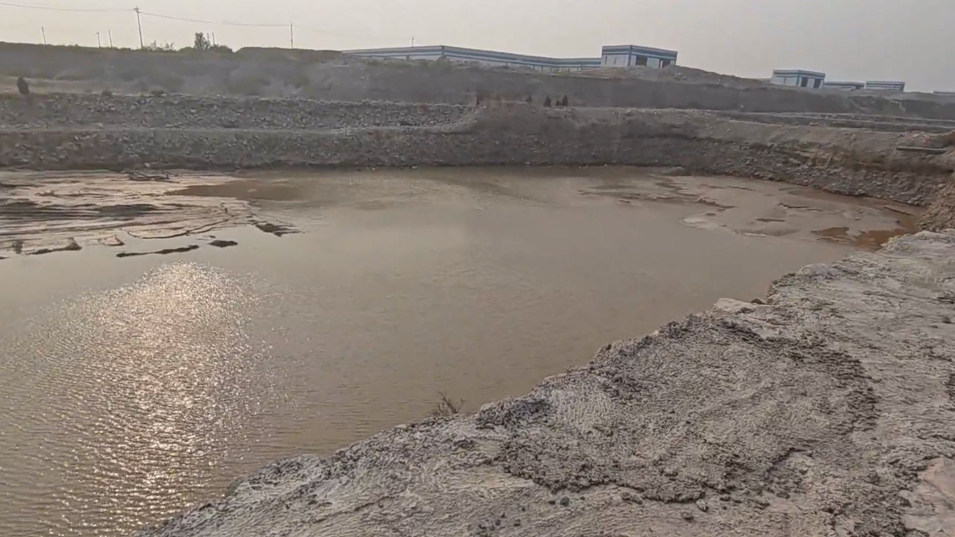 河南辉县一公司无证采砂河道形成2个巨大采坑：废料凌乱堆存滩地