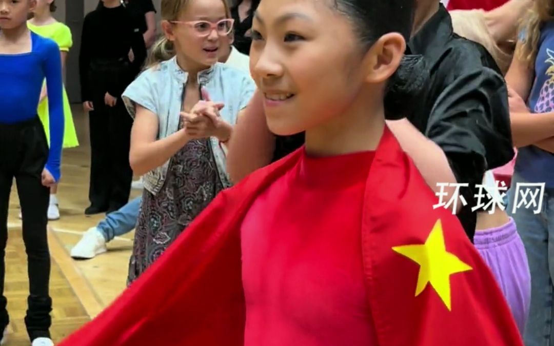 女孩在国际舞蹈比赛中夺冠，身披五星红旗优雅登上领奖台