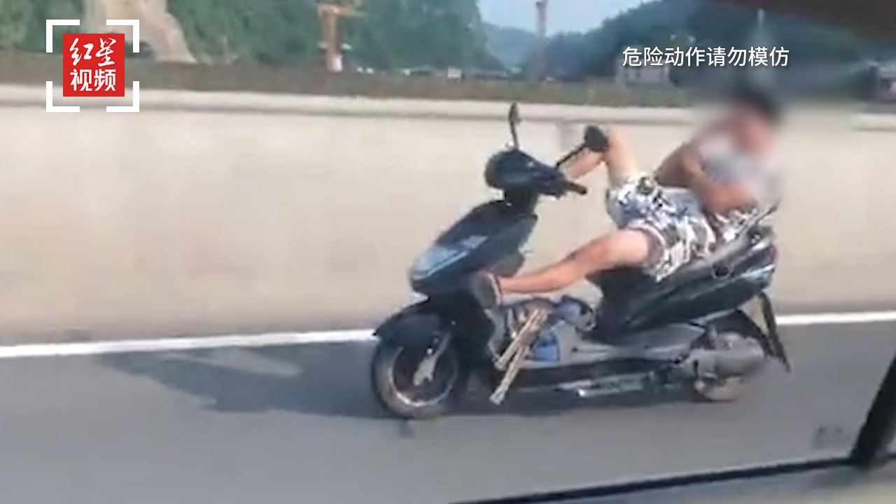 男子躺着驾驶电瓶车 双手脱把玩手机游戏 交警：严肃处理