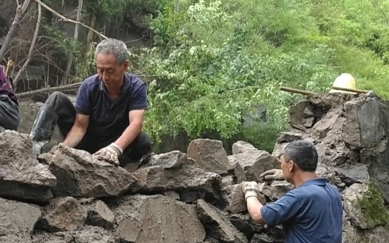暴雨冲下石头砸断水渠坝，村民及时抢修！