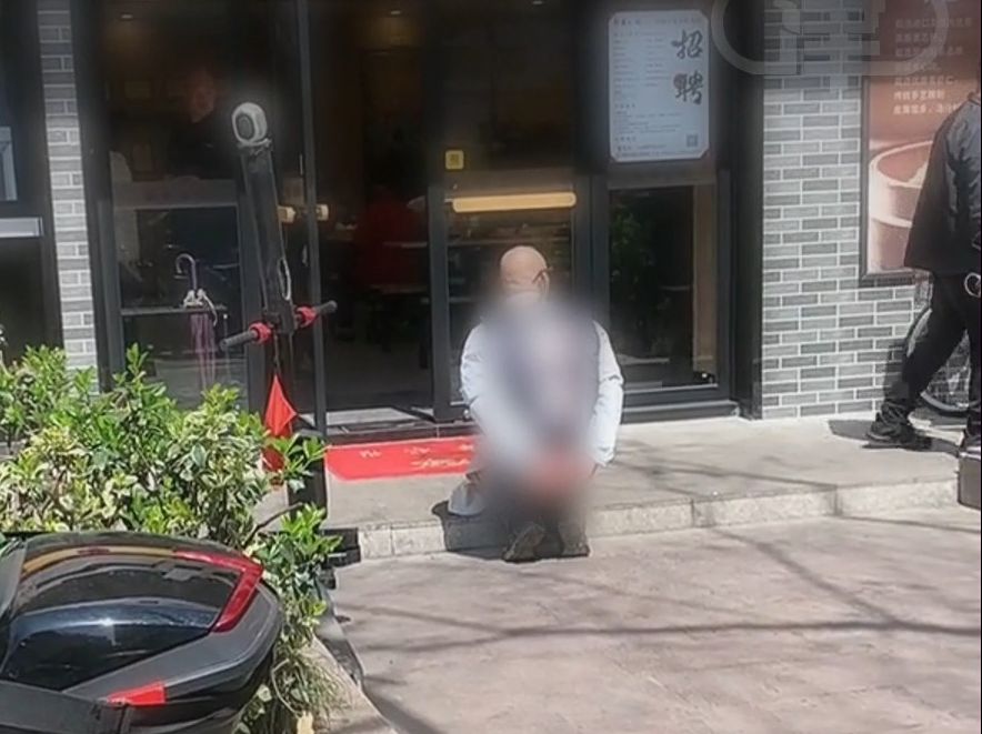 杭州一男子在闹巿街头小吃店前下跪 店方：行为过激，已报警处理